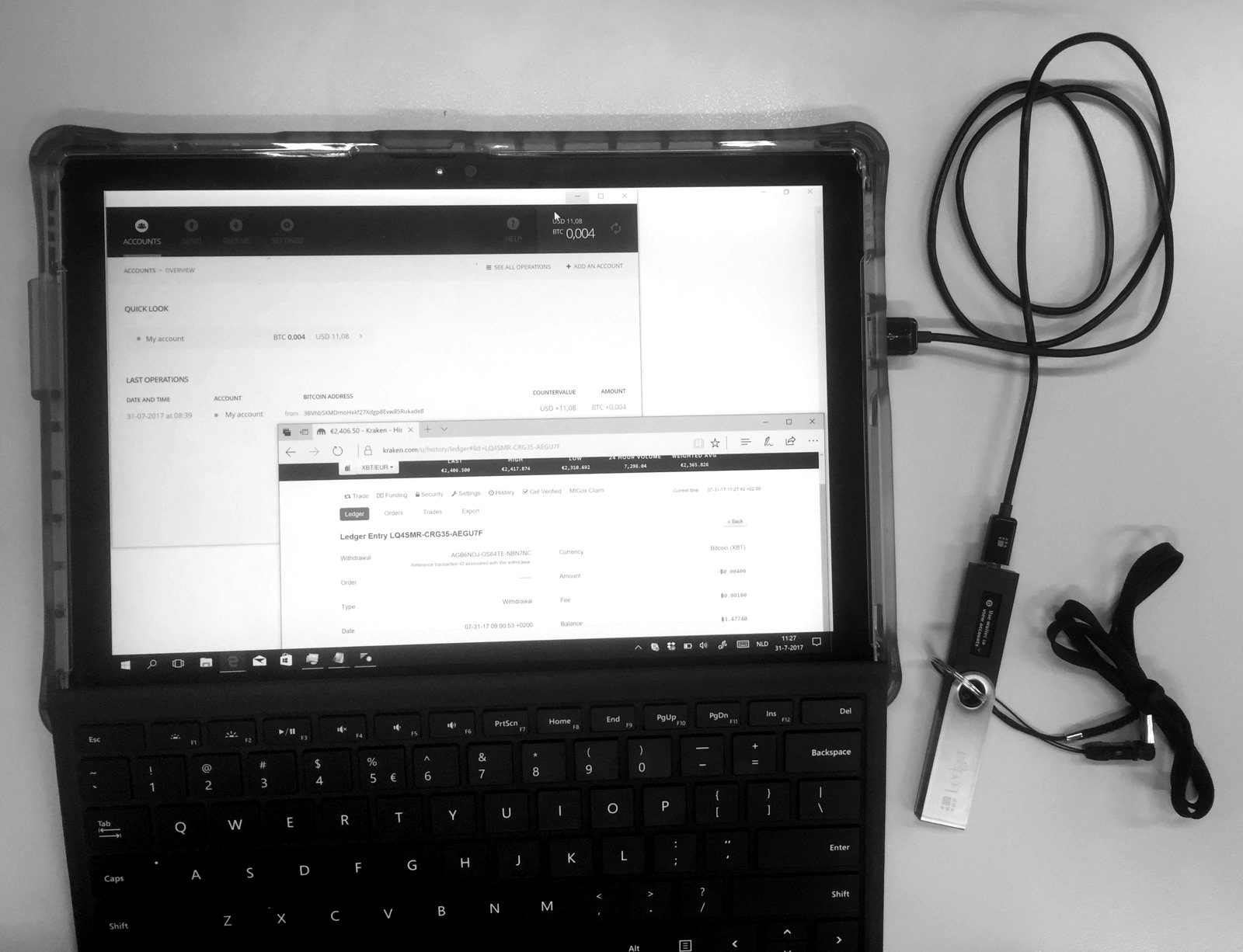 A tablet showing a blockchain explorer next to a hardware wallet on a cable