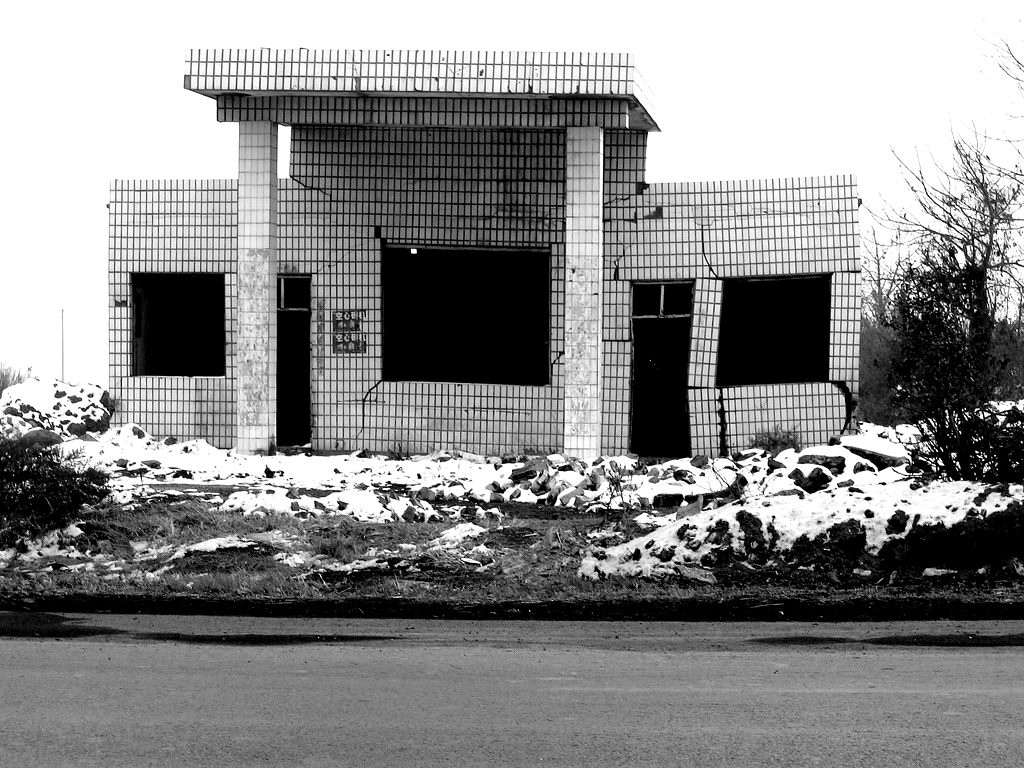An abandoned concrete building with empty windows, in black and white