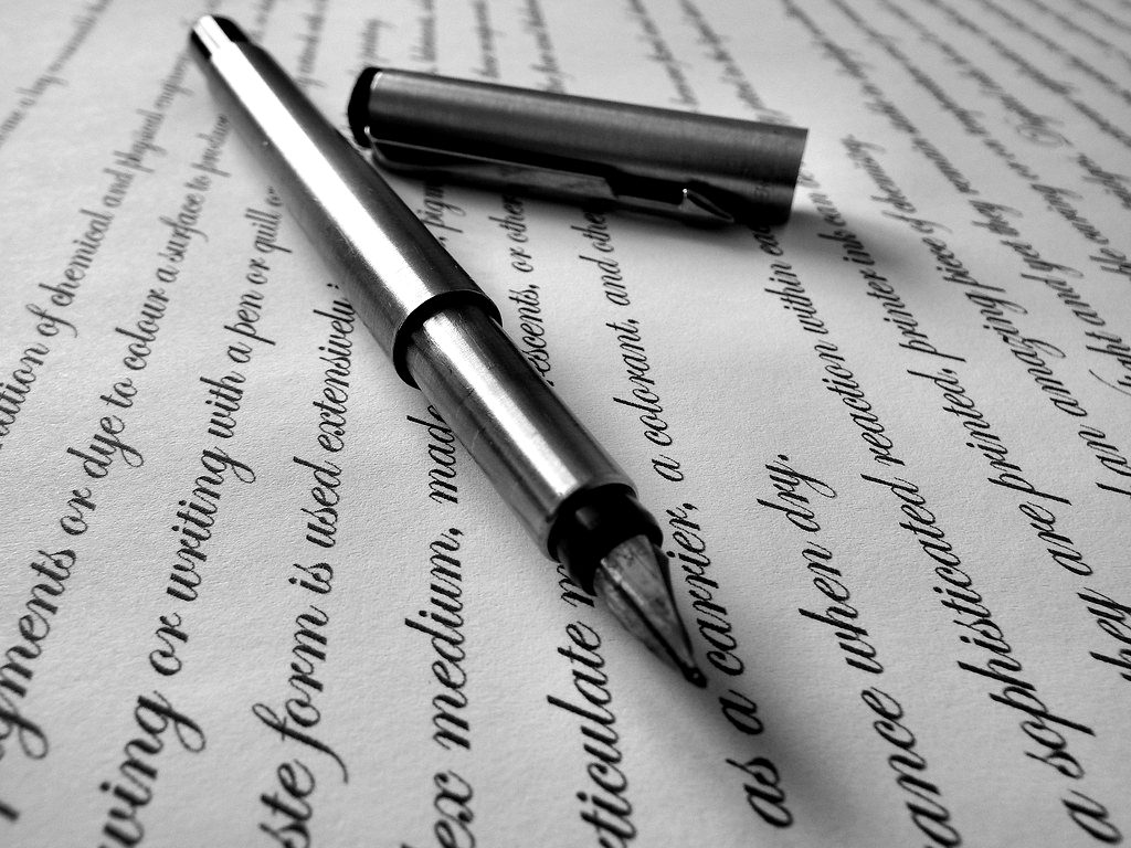 A fountain pen lying on pages of printed text