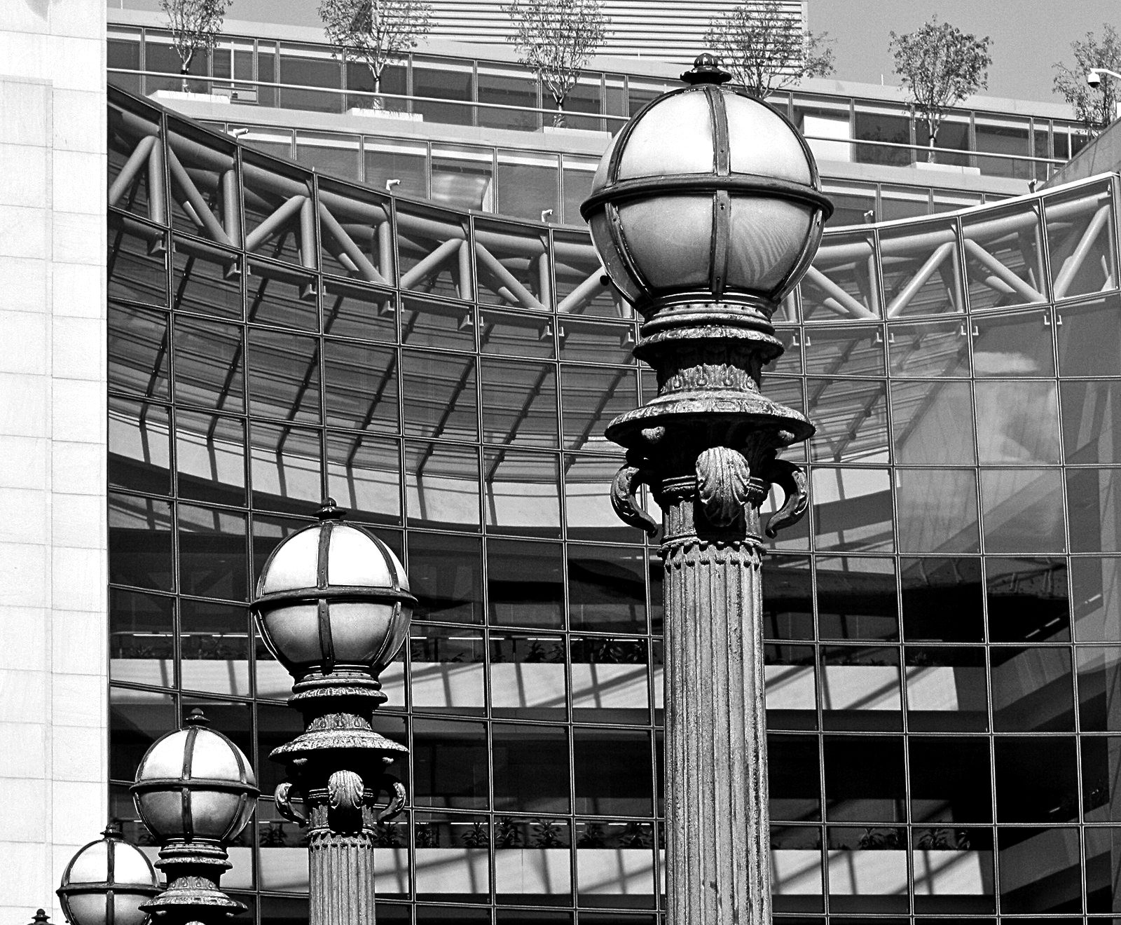 Ornamental lamp posts in front of a glass office building