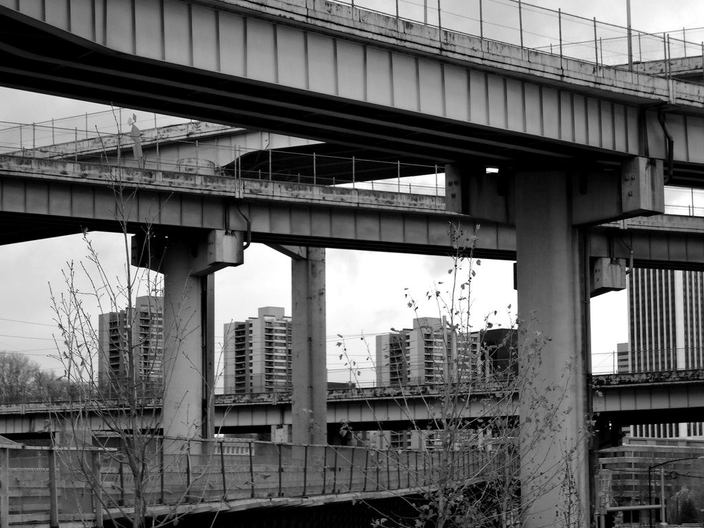 Two levels of road viaduct crossing over an older stone bridge