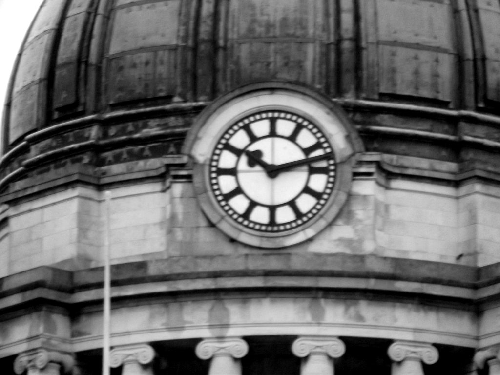 A clock set into the stone dome of a bank building