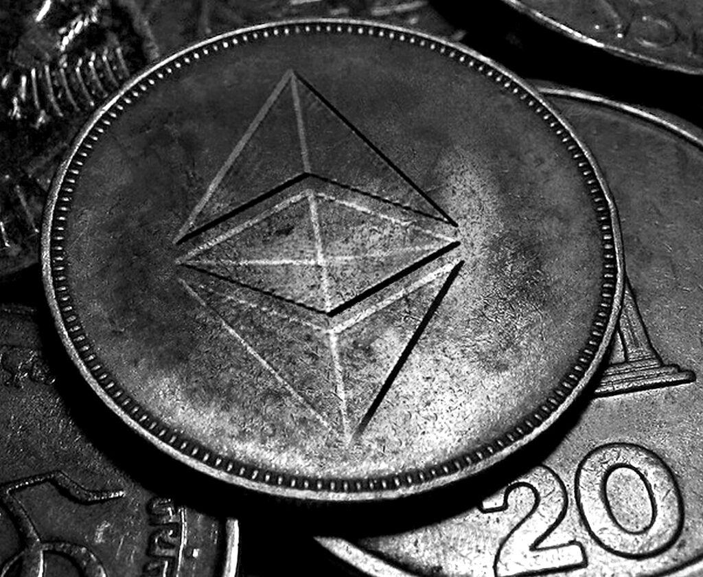 Close-up of a coin engraved with the Ethereum diamond under green light
