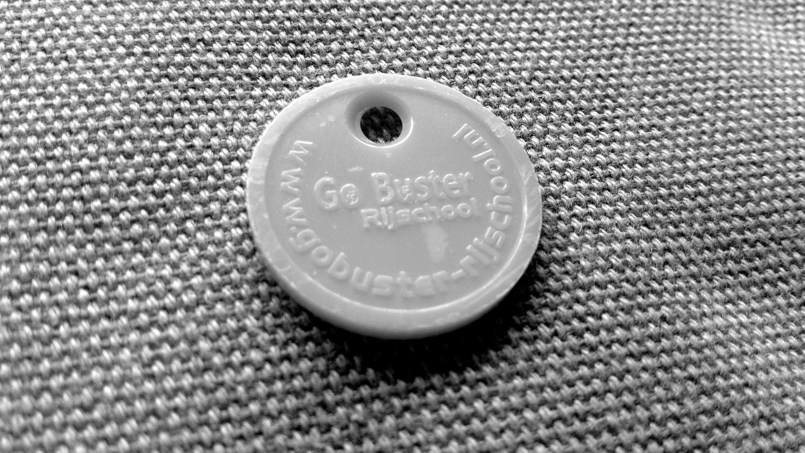 A yellow plastic token with a hole for a key ring